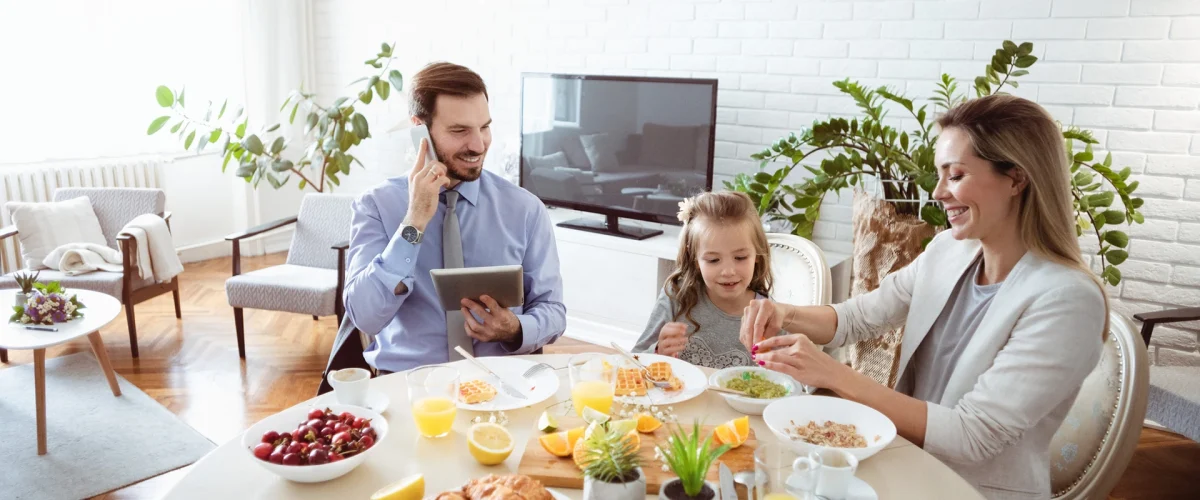 Familie samlet rundt frokostbordet i et lyst og ryddig hjem etter sommerferien