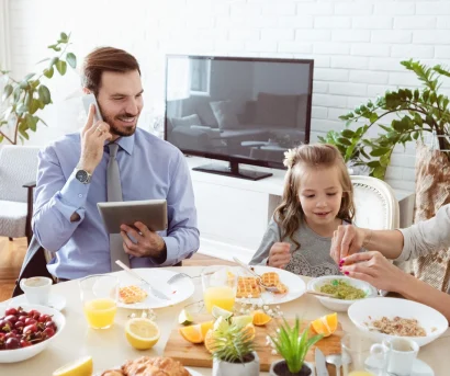 Familie samlet rundt frokostbordet i et lyst og ryddig hjem etter sommerferien