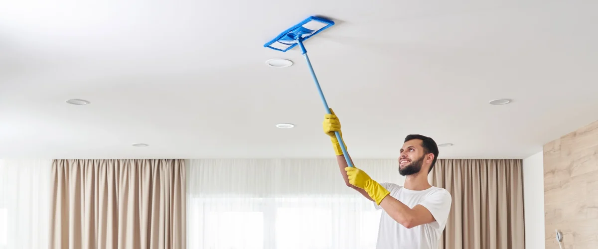 Mann rengjør taket etter oppussing