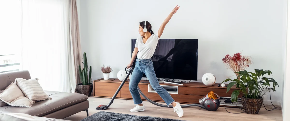 Dame har storrengjøring i hjemmet mens hun danser til musikk