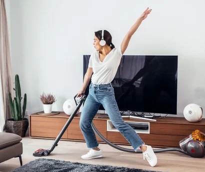 Dame har storrengjøring i hjemmet mens hun danser til musikk