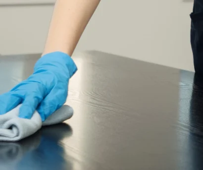 Hånd som vasker bord med mikrofiberklut